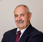 A man with a mustache and a suit and tie.