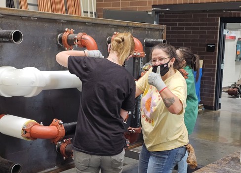 A man and a woman looking at a man in a mask.