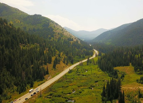A road with trees and mountains.