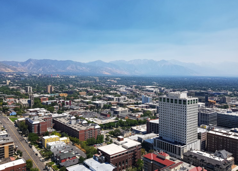 A city with many buildings and mountains in the background.