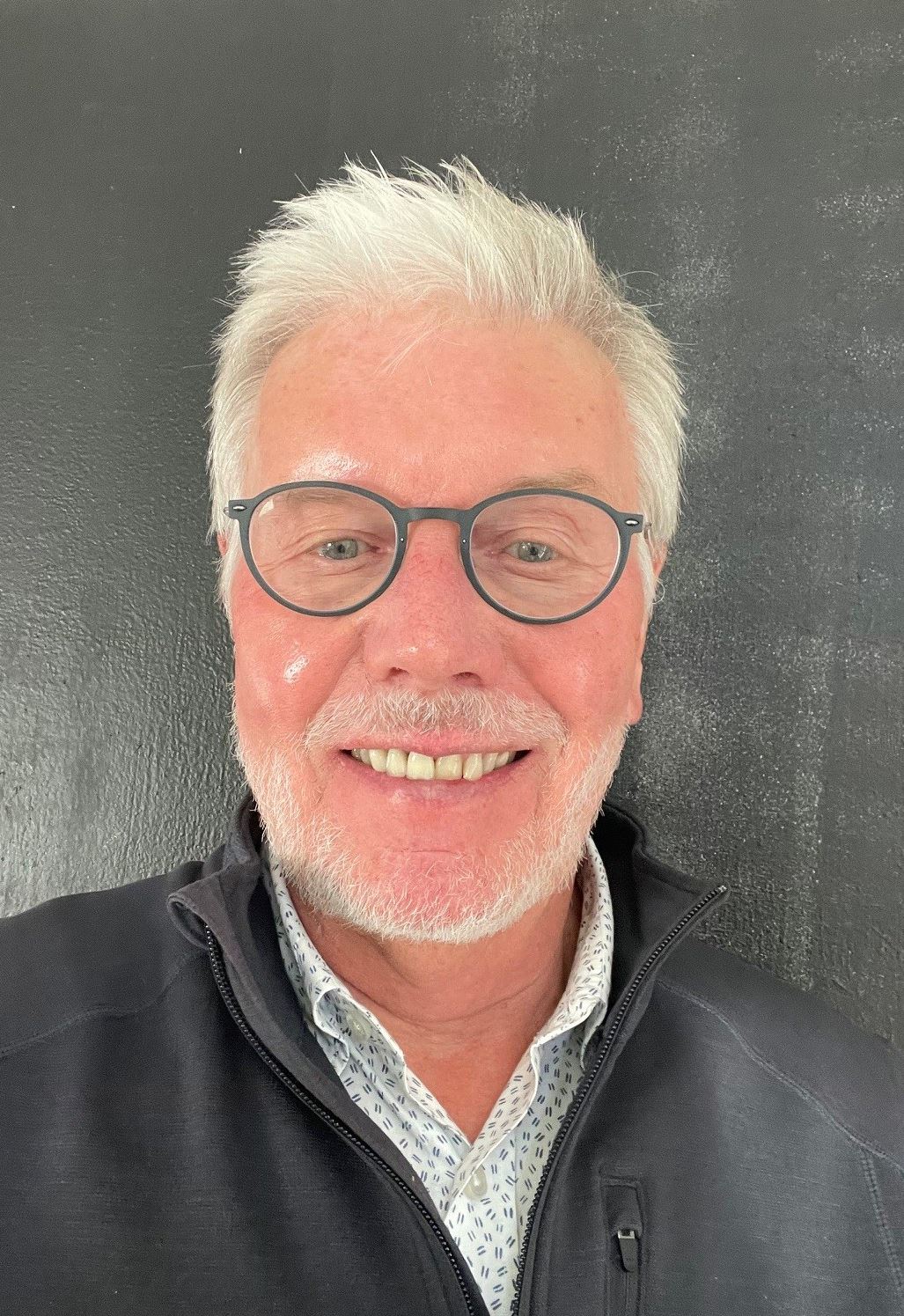 A man with white hair and glasses.