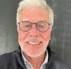 A man with white hair and glasses.