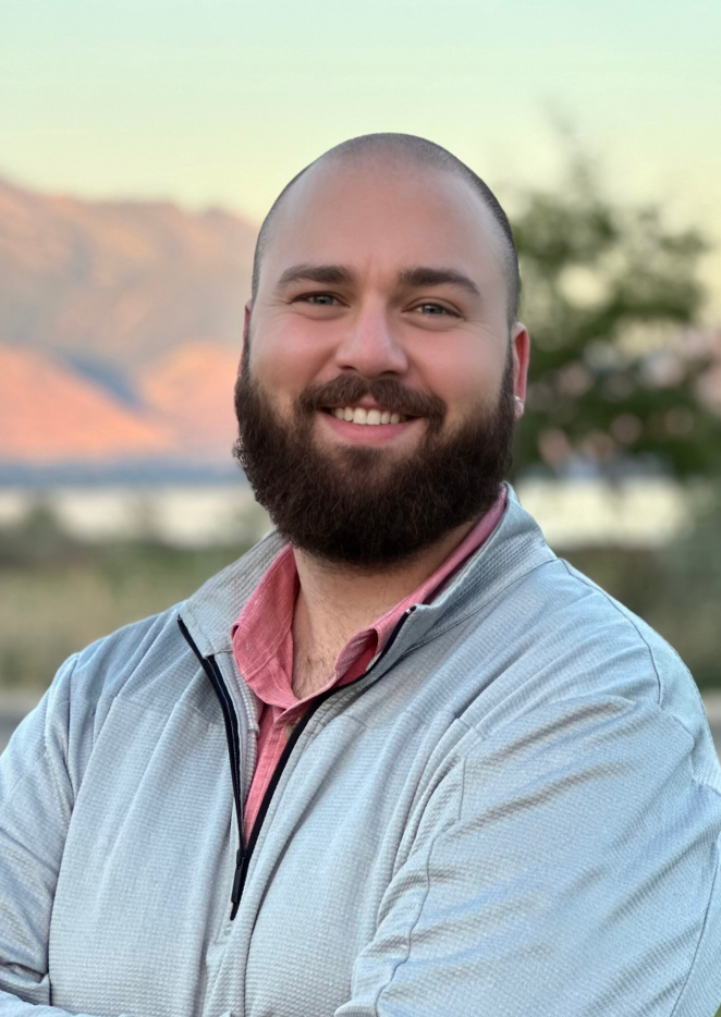 A man with a beard smiling.
