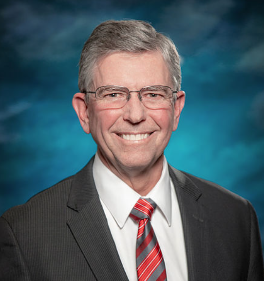 Chet D. Traylor wearing glasses and a suit.