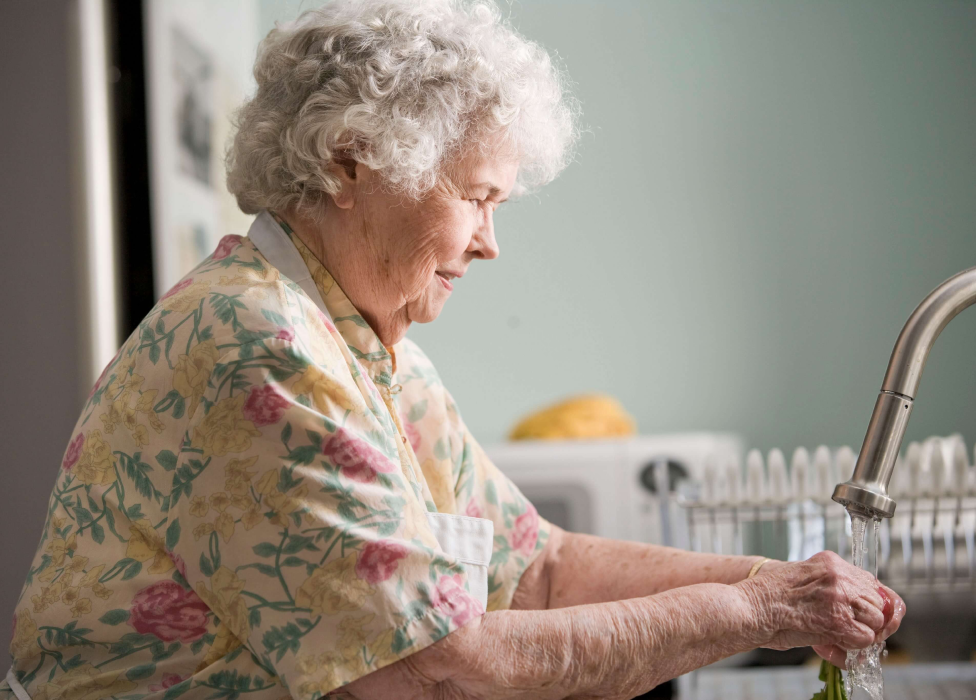 An old woman washing the hands.