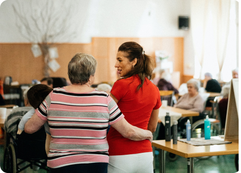 A woman and a man in a room with tables and chairs.