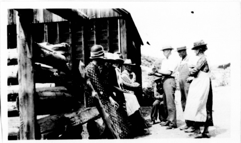 A group of people standing outside a hut.