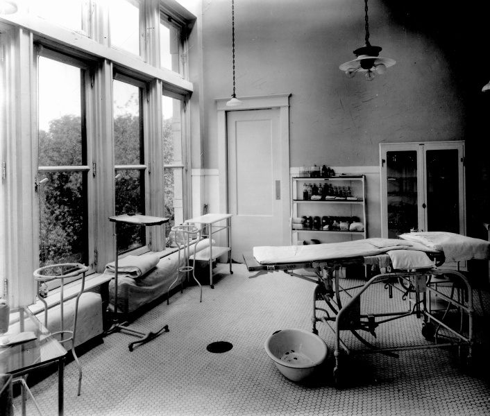 A room with a bed and tables.