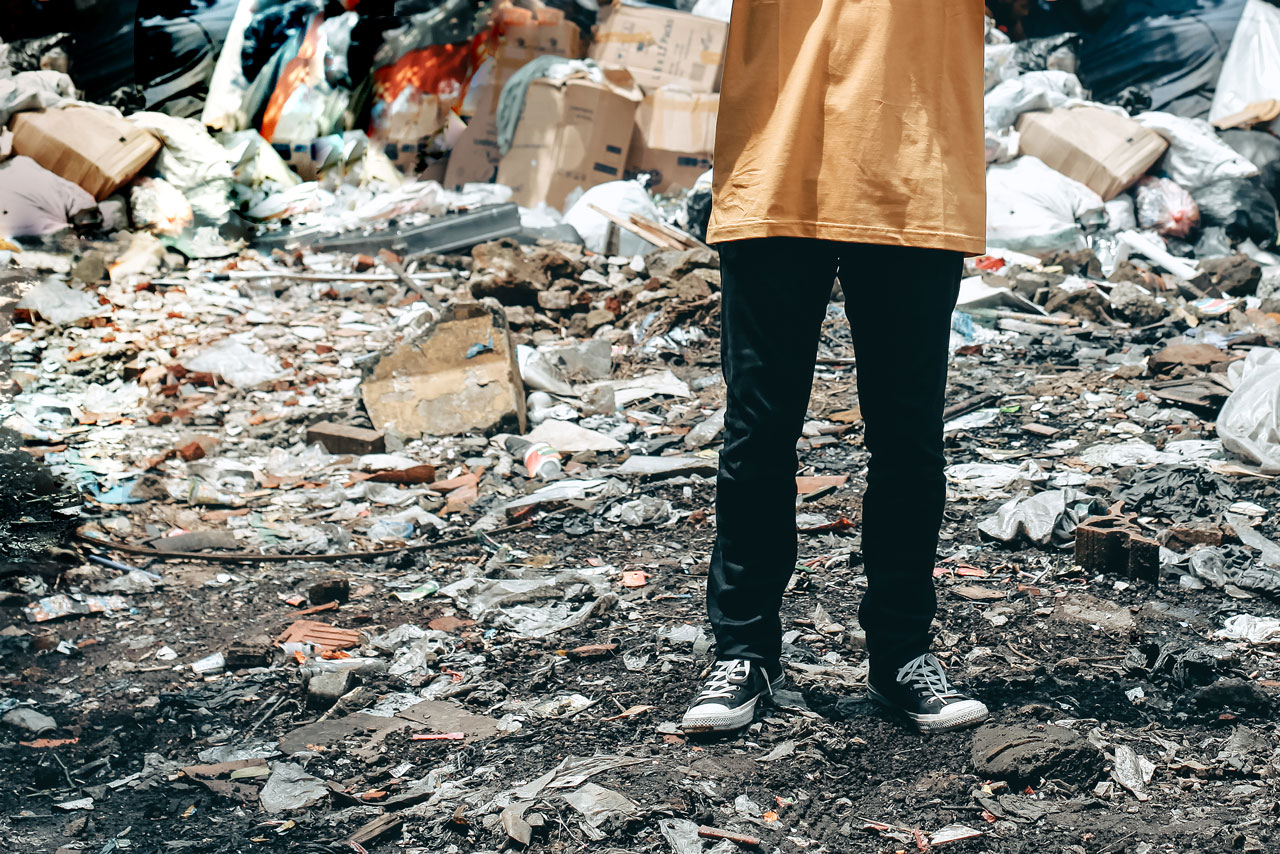 A person standing in a pile of trash.