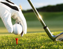 A golf club hitting a ball.
