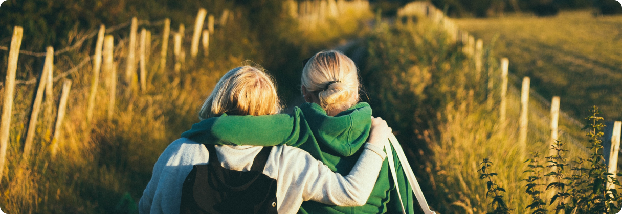 Two people hugging in a field.