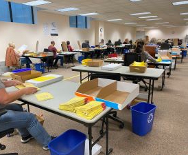A group of people in a room counting ballots.