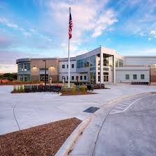 A flag on a pole in front of a building.