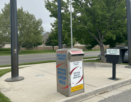 A row of mailboxes on a sidewalk.