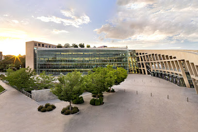 A building with trees and bushes in front of it.