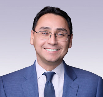 Ross I. Romero wearing a blue suit and tie.