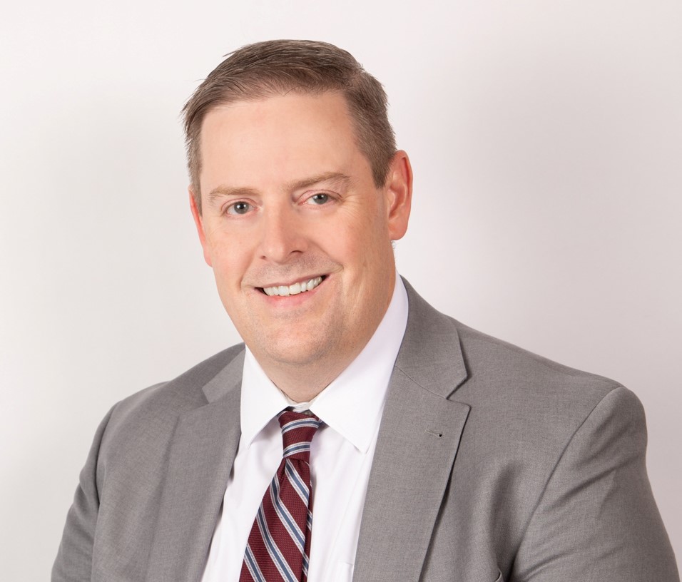 A man in a suit smiling.