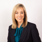 Aimee Winder Newton in a suit smiling.