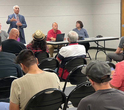 A man standing in front of a group of people sitting at tables.