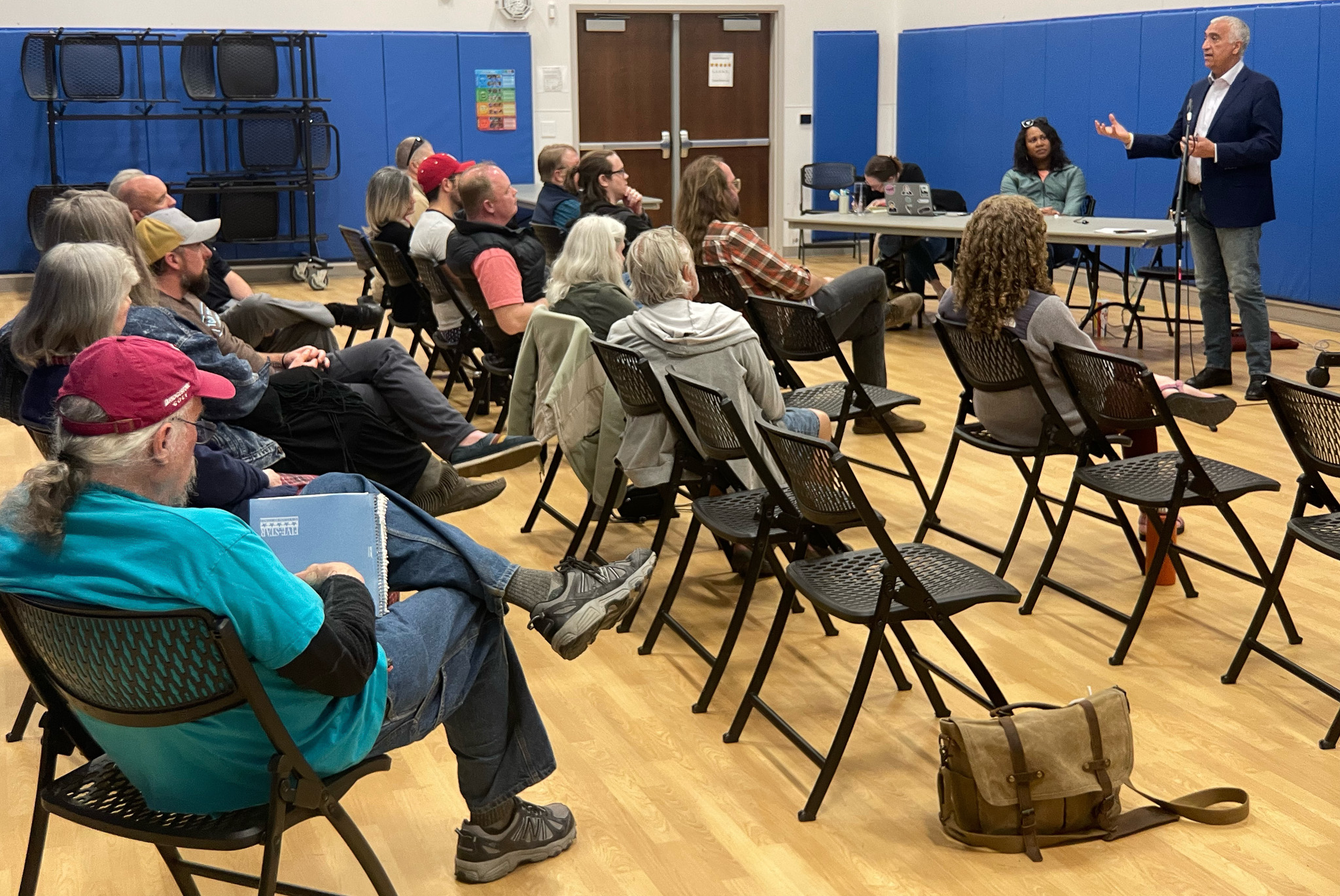A person standing in front of a group of people sitting in chairs.