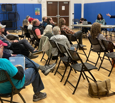 A person standing in front of a group of people sitting in chairs.