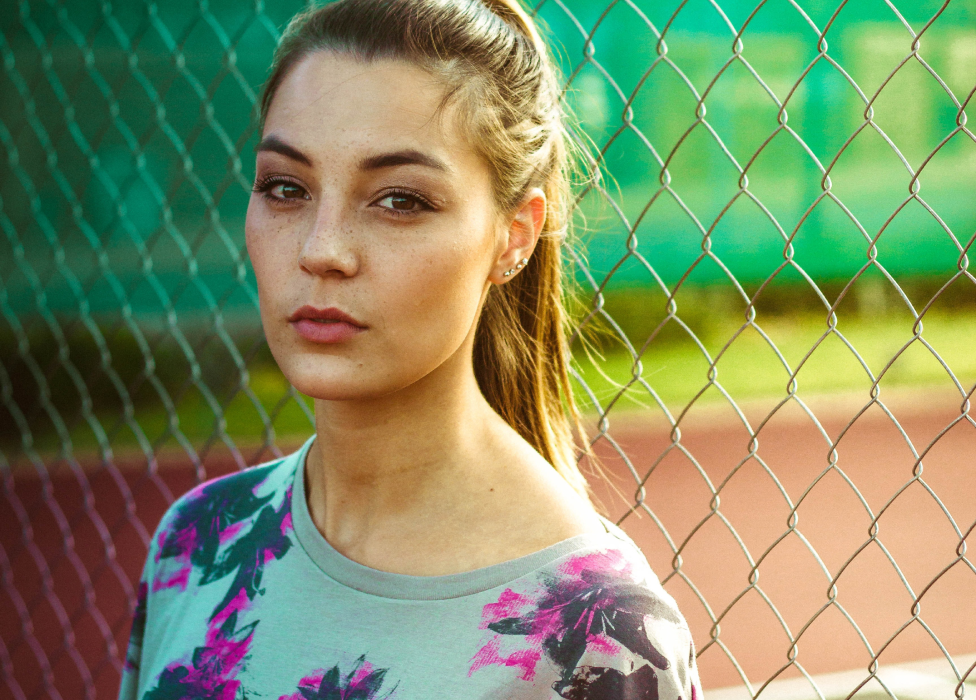 A woman behind a fence.