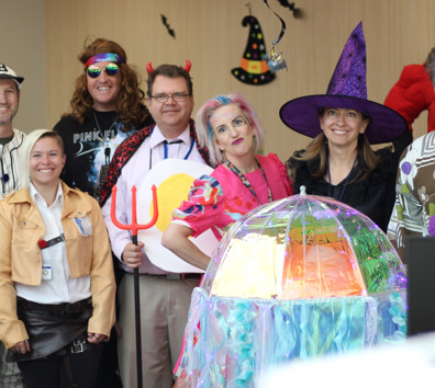 A group of people posing for a photo with a large balloon.