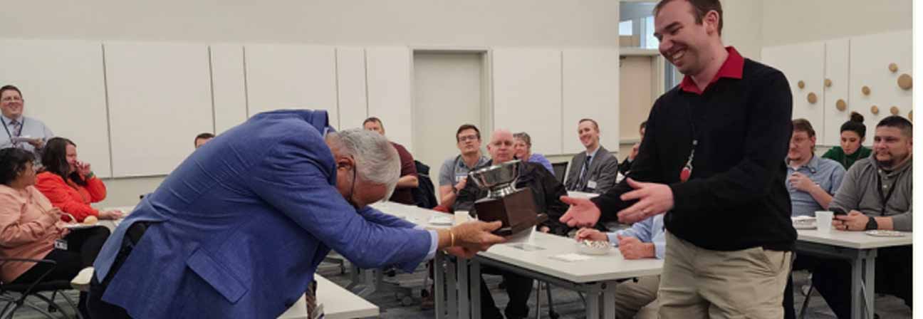A man shaking hands with a man in a suit.