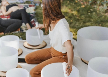A person sitting at a table with a group of white cups.