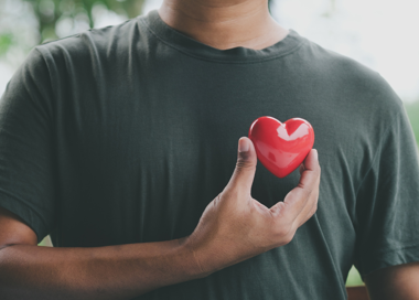 A person holding a red heart.
