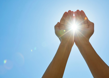 A hand holding a glowing light.