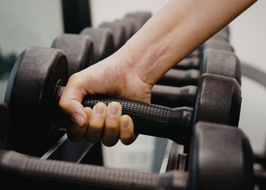 A close-up of a person's hand on a chair.