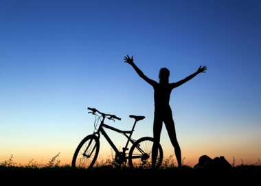 A person standing next to a bicycle.