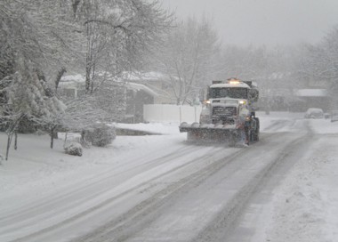 A truck driving on a snowy road.