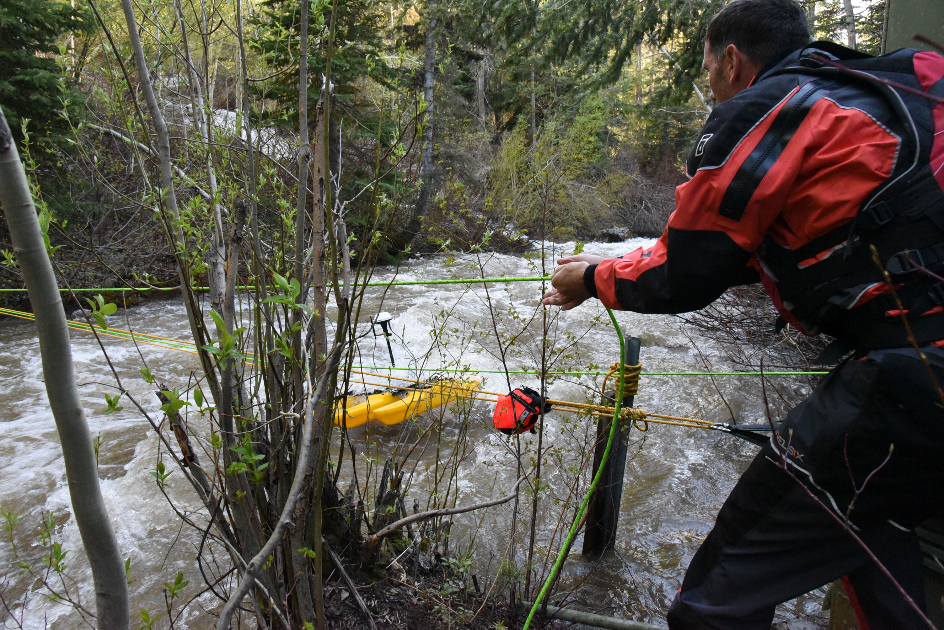 A man holding a cable and sampling water.