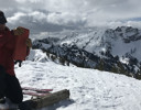 A man testing snow on a mountain.