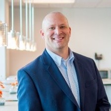 A man in a suit smiling.