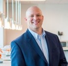 A man in a suit smiling.