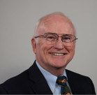 A man wearing glasses and a suit.