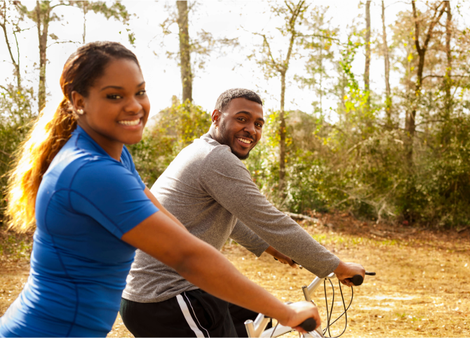 A man and a woman riding a bicycle.