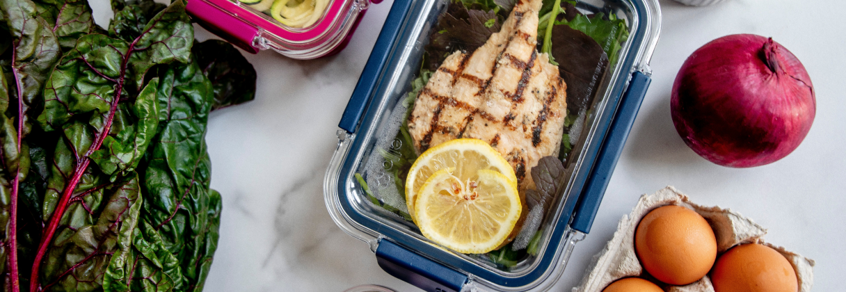 A blue basket with food and a couple of eggs.