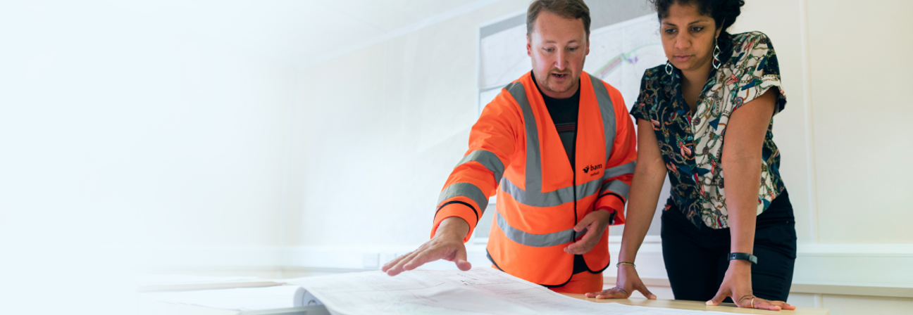 A man and a woman looking at a paper.
