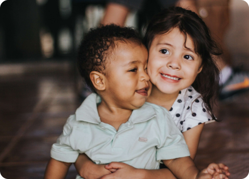 A couple of children hugging.