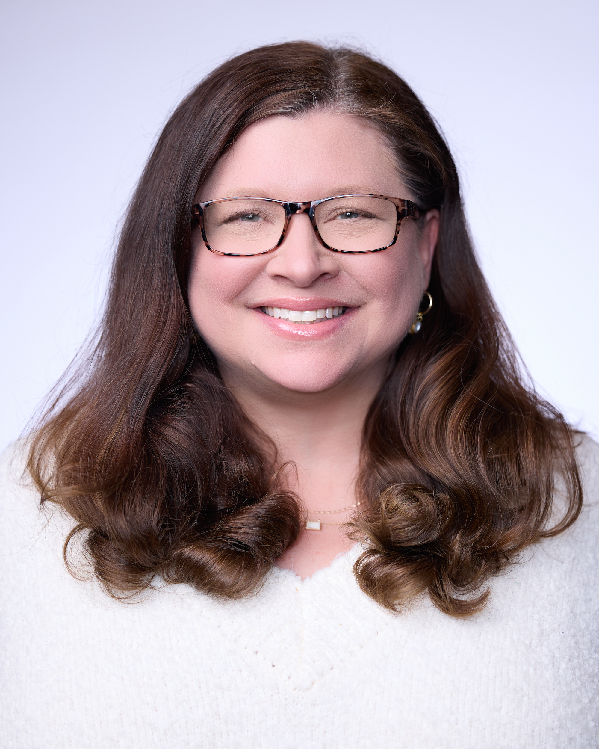 A woman with long hair smiling.