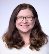 A woman with long hair smiling.