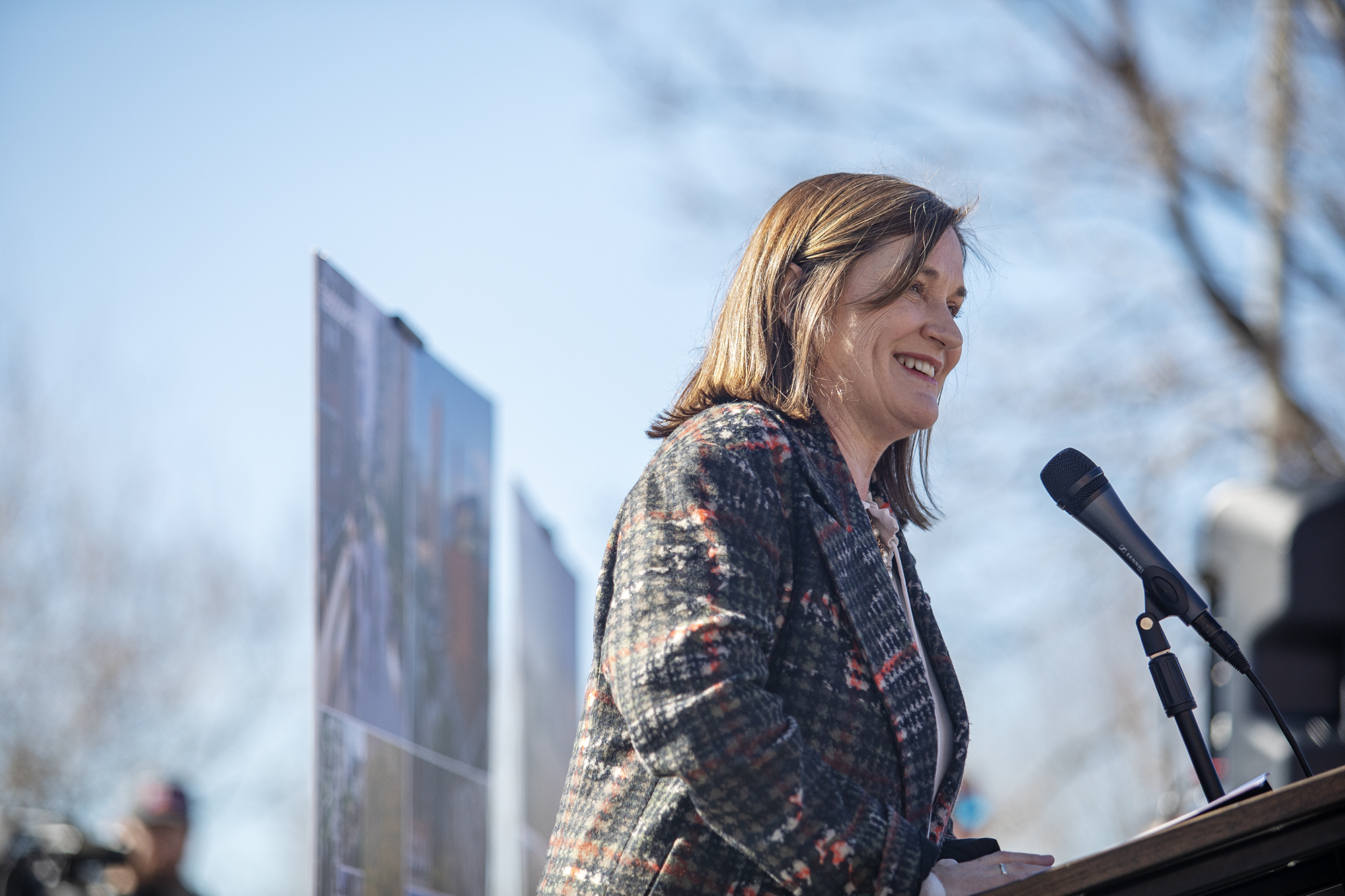 A person smiling at a podium.