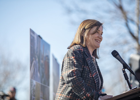 A person smiling at a podium.