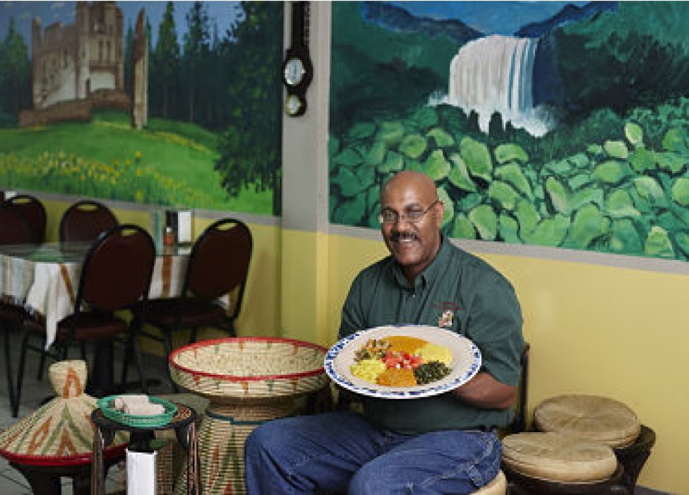 A person sitting at a table with a plate of food.