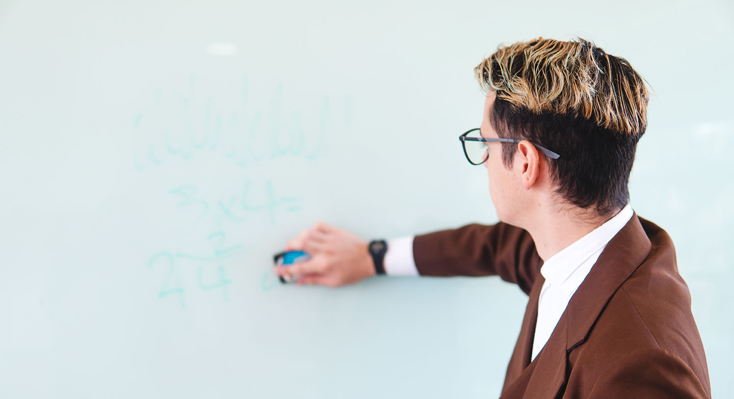 A man writing on a whiteboard.