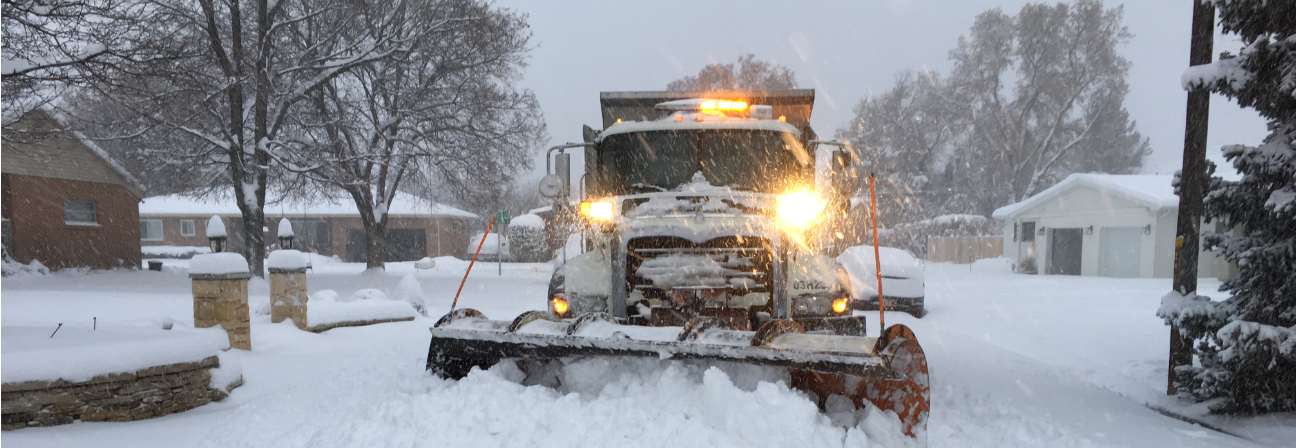 A snow blower in a snowy yard.